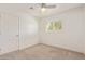 Clean bedroom features carpet flooring, modern ceiling fan, and a window with shutter-style blinds at 520 W Townley Ave, Phoenix, AZ 85021