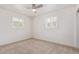 This is a bedroom featuring a ceiling fan and plantation shutters on two windows, with neutral carpet at 520 W Townley Ave, Phoenix, AZ 85021