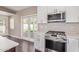 Updated kitchen featuring stainless steel appliances, white cabinetry, and backyard view at 520 W Townley Ave, Phoenix, AZ 85021