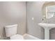 Stylish powder room with pedestal sink, round mirror, and modern fixtures at 520 W Townley Ave, Phoenix, AZ 85021