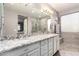 Bright bathroom features a double vanity with granite countertop, grey tile flooring, and glass-enclosed shower at 631 W Stanley Ave, San Tan Valley, AZ 85140