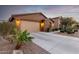 Charming house with two-car garage, a well-maintained lawn and desert landscaping around the house at 631 W Stanley Ave, San Tan Valley, AZ 85140