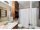Cozy bathroom featuring a vanity sink, toilet, shower with curtain, and dark wood cabinet at 7102 W Wilshire Dr, Phoenix, AZ 85035