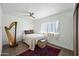 Bright bedroom with ceiling fan, wood floors, a comfortable bed, and harp at 7102 W Wilshire Dr, Phoenix, AZ 85035