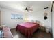 Bright bedroom featuring a ceiling fan, window with a view, and tasteful decorations at 7102 W Wilshire Dr, Phoenix, AZ 85035