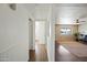 Hallway with wood floors leading into a spacious living room with area rug and lots of light at 7102 W Wilshire Dr, Phoenix, AZ 85035