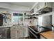 Bright kitchen featuring stainless steel appliances, butcher block countertops, and open shelving at 7102 W Wilshire Dr, Phoenix, AZ 85035