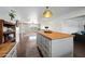 Kitchen island with butcher block top, painted gray base, and ample storage space at 7102 W Wilshire Dr, Phoenix, AZ 85035
