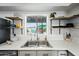 Close up of a stainless steel kitchen sink with butcher block countertops and open shelving at 7102 W Wilshire Dr, Phoenix, AZ 85035