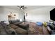 Cozy living room featuring a large sectional sofa, ceiling fan, and classic paneled walls at 7102 W Wilshire Dr, Phoenix, AZ 85035