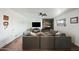 Cozy living room with brick fireplace, large TV, and comfortable sectional sofa at 7102 W Wilshire Dr, Phoenix, AZ 85035
