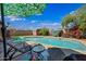 Tranquil pool setting with umbrella-covered lounge chairs and flowering plants at 7102 W Wilshire Dr, Phoenix, AZ 85035