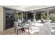 A sun-drenched dining area with a glass table, modern chairs, and views of lush outdoor scenery at 7121 E Rancho Vista Dr # 1008, Scottsdale, AZ 85251