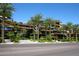 Beautiful multi-story condominium building with lush greenery and palm trees against a clear blue sky at 7121 E Rancho Vista Dr # 1008, Scottsdale, AZ 85251