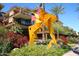 Beautifully landscaped exterior with striking modern art installation, palm trees, and colorful plants at 7121 E Rancho Vista Dr # 1008, Scottsdale, AZ 85251