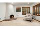 Cozy bedroom nook with a fireplace and comfortable chair near shuttered windows at 8325 N 73Rd Pl, Scottsdale, AZ 85258