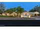Elegant stucco home with tile roof, manicured lawn, and mature trees providing shade and curb appeal at 8325 N 73Rd Pl, Scottsdale, AZ 85258