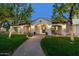 Charming home with brick walkway, arched entryway, manicured lawn, and mature trees at 8325 N 73Rd Pl, Scottsdale, AZ 85258