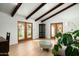 Bright living room with wood floors, exposed beams, and French doors, creating a cozy atmosphere at 8325 N 73Rd Pl, Scottsdale, AZ 85258