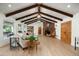 Open living room featuring vaulted ceilings, exposed beams, and a stone fireplace at 8325 N 73Rd Pl, Scottsdale, AZ 85258