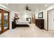 Bright main bedroom with a ceiling fan and a view of the fireplace through the mirror at 8325 N 73Rd Pl, Scottsdale, AZ 85258