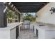Covered outdoor kitchen with grill, sink, refrigerator, and counter space perfect for cooking and entertaining at 8325 N 73Rd Pl, Scottsdale, AZ 85258