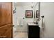 Elegant powder room with dark vanity, stylish mirror, and decorative chandelier at 8325 N 73Rd Pl, Scottsdale, AZ 85258