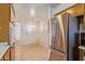 Galley kitchen featuring classic wooden cabinets, stainless steel fridge, and adjacent dining area at 9022 N 39Th Ave, Phoenix, AZ 85051