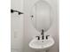 Modern powder room with a pedestal sink, matte black fixtures and oval mirror at 11447 E Utah Ave, Mesa, AZ 85212