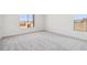 Bright bedroom with gray carpet, natural light and view to rooftops from the double paned window at 11447 E Utah Ave, Mesa, AZ 85212