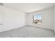 Bright bedroom with gray carpet, natural light and view to rooftops from the paned window at 11447 E Utah Ave, Mesa, AZ 85212