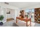 Well-lit home office with a wooden desk, bookshelves, and a view of the neighborhood at 11447 E Utah Ave, Mesa, AZ 85212