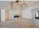 Bright and airy living room with whitewashed brick fireplace, beamed ceiling, hardwood floor, and modern chandelier at 11841 N 65Th Pl, Scottsdale, AZ 85254