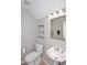 Cozy powder room with white fixtures, neutral walls, floating shelves and modern lighting at 1227 E Sheena Dr, Phoenix, AZ 85022