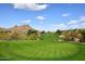 Scenic golf course view with lush green fairway, mountain backdrop, and blue skies with fluffy white clouds at 1227 E Sheena Dr, Phoenix, AZ 85022