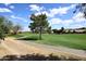 Scenic golf course view featuring lush green grass, mature trees, sand traps and an asphalt cart path at 1227 E Sheena Dr, Phoenix, AZ 85022