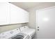 Practical laundry room featuring a washer, dryer, and ample storage cabinets at 1227 E Sheena Dr, Phoenix, AZ 85022