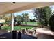 Inviting covered patio overlooking the backyard and golf course with table and chairs at 1227 E Sheena Dr, Phoenix, AZ 85022