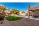 A spacious backyard featuring a sparkling pool, a well-manicured lawn, covered patio and desert landscaping for easy maintenance at 13212 W Lisbon Ln, Surprise, AZ 85379