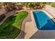 Aerial shot of the backyard featuring a sparkling pool, well-kept lawn, and desert landscape, fully enclosed for privacy at 13212 W Lisbon Ln, Surprise, AZ 85379