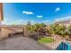 An outdoor balcony view showcasing a well-maintained backyard with a pool and green lawn, surrounded by desert landscaping at 13212 W Lisbon Ln, Surprise, AZ 85379