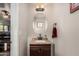 Charming powder room featuring a dark wood vanity and oval mirror, illuminated by a stylish light fixture at 13212 W Lisbon Ln, Surprise, AZ 85379