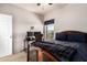 Bedroom with a wooden frame bed, a window, and a workspace with two monitors at 13212 W Lisbon Ln, Surprise, AZ 85379