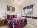 Bright bedroom featuring a wrought iron bed frame and window seat with patterned curtains at 13212 W Lisbon Ln, Surprise, AZ 85379