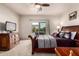 Well-lit Primary bedroom with a balcony view, paired with dark wood furniture for a touch of elegance at 13212 W Lisbon Ln, Surprise, AZ 85379