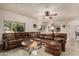 Cozy living room with leather sectional, ceiling fan, and ample natural light at 13212 W Lisbon Ln, Surprise, AZ 85379