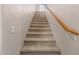 Carpeted staircase with wood railing leading to the upper level, offering a safe and stylish passage at 13212 W Lisbon Ln, Surprise, AZ 85379