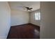 An empty bedroom featuring glossy hardwood floors, a ceiling fan, and a bright window at 13805 N 31St Ave, Phoenix, AZ 85053