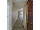 Hallway with tile flooring and a partial brick wall at 13805 N 31St Ave, Phoenix, AZ 85053