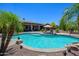 Beautiful backyard pool with mature landscaping, covered patio, and relaxing lounge chairs at 14124 W Christy Dr, Surprise, AZ 85379